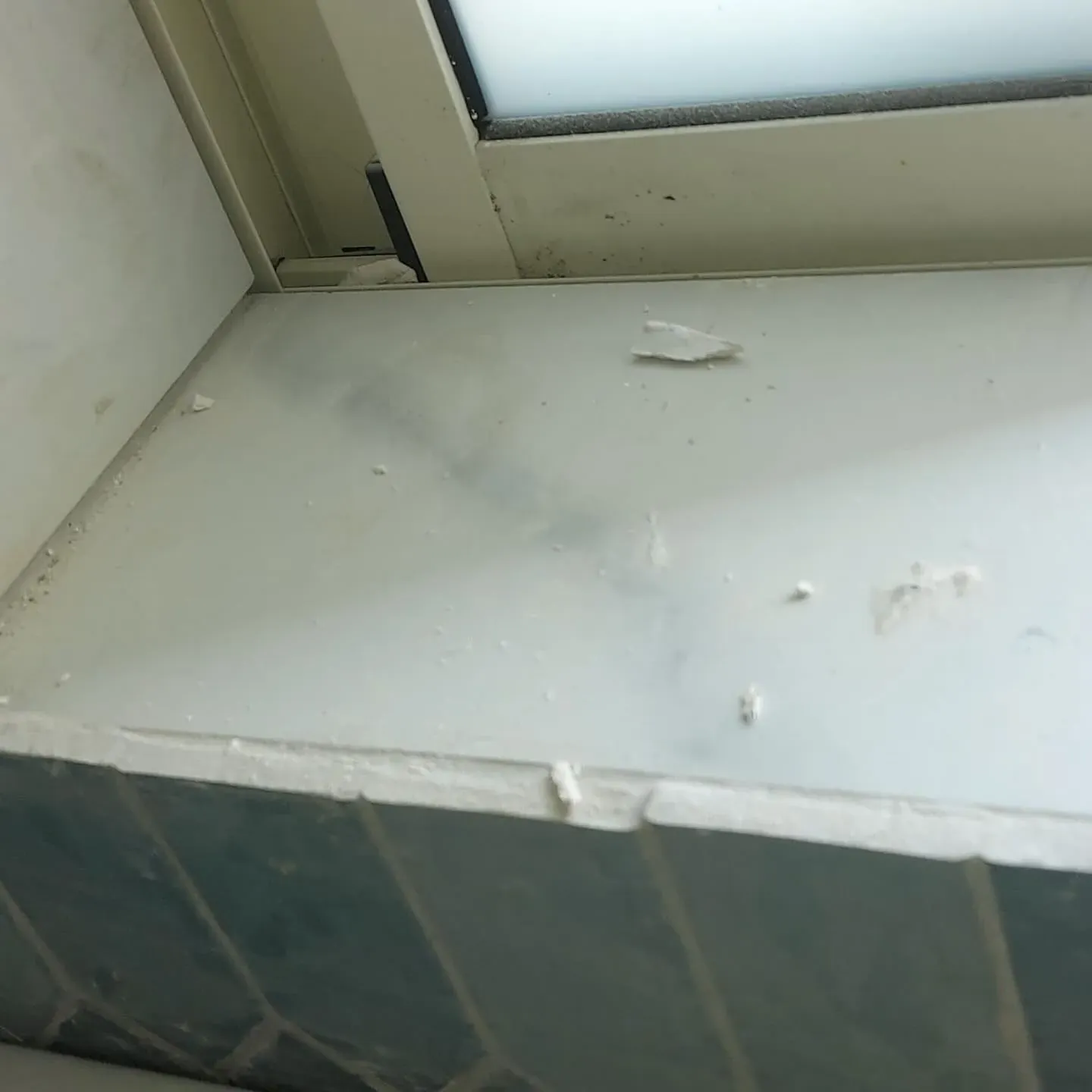 אדן חלון מכוסה אבק ושאריות טיח מהשיפוץ